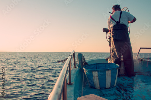 Obraz na płótnie Fishing on boat in sea. Sunset