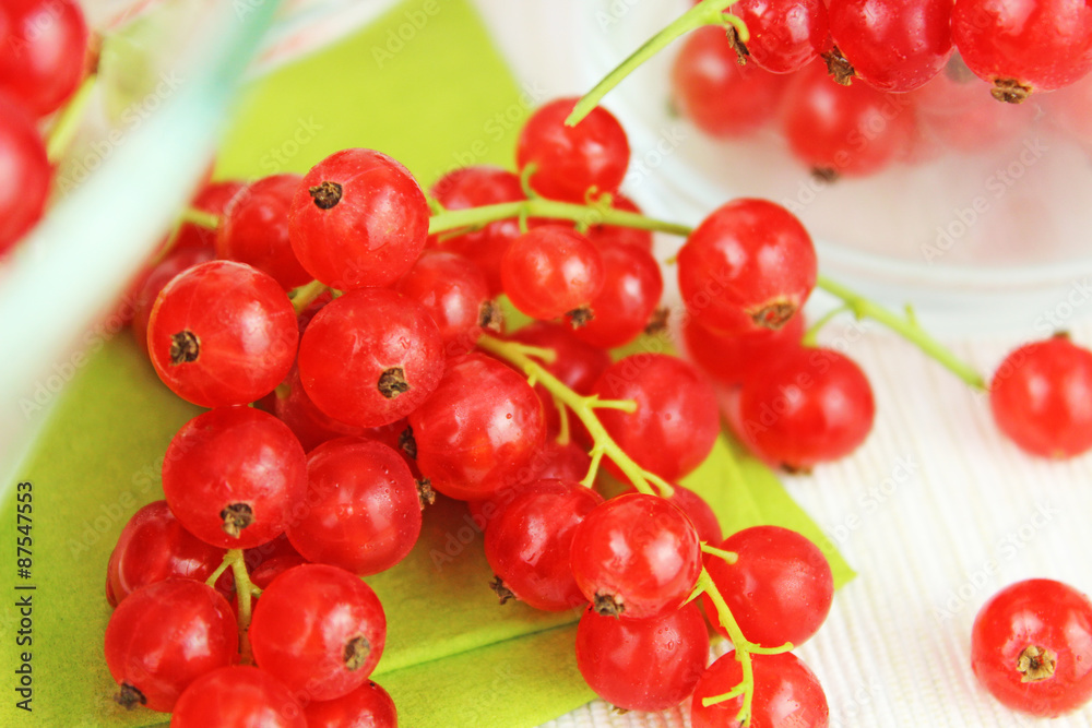 Johannisbeeren in Schale aus Glas und auf Esstisch auf grüner Serviette Johannisbeeren in Schale aus Glas und auf Esstisch auf grüner Serviette