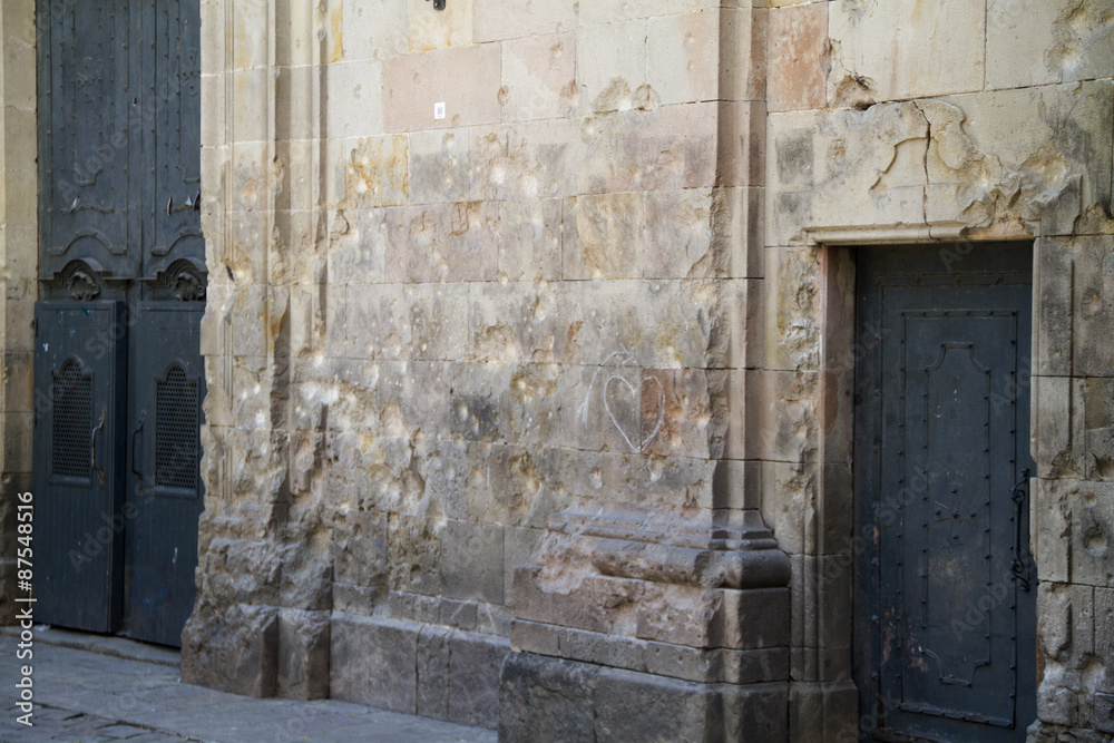 Facade of church in the Barri Gotic (Gothic Quarter) potmarked with bullet holes from the Spanish Civil War.Barcelona,Spain Facade of church in the Barri Gotic (Gothic Quarter) potmarked with bullet holes from the Spanish Civil War.Barcelona,Spain