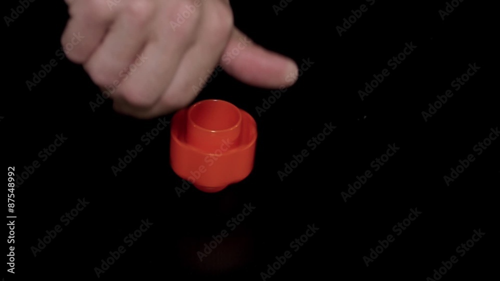 Slowmotion spinning whirligig spinner toy tool on black background Slowmotion spinning whirligig spinner toy tool on black background