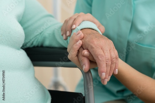 Nurse supporting old woman photo