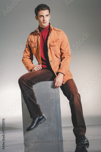 handsome young male model sitting cube - studio shoot