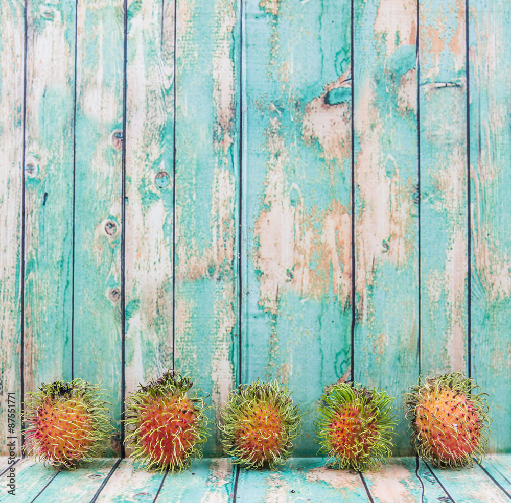 Fototapeta premium Sweet, exotic and delicious rambutan fruit over wooden background