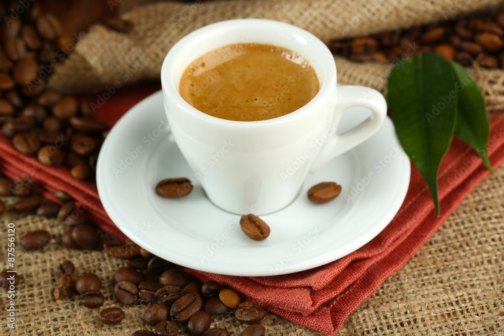 Cup of coffee with beans on table close up Cup of coffee with beans on table close up