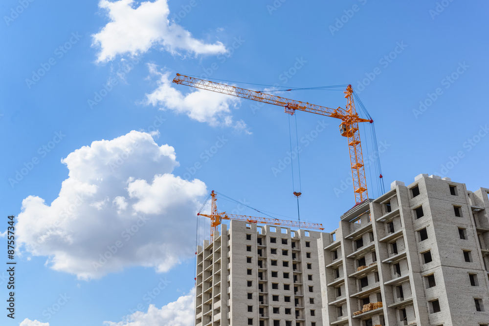 Tall cranes on a blue sky background