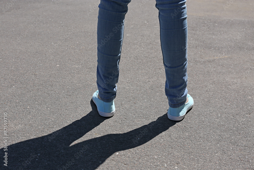 Female feet on gray asphalt background Female feet on gray asphalt background