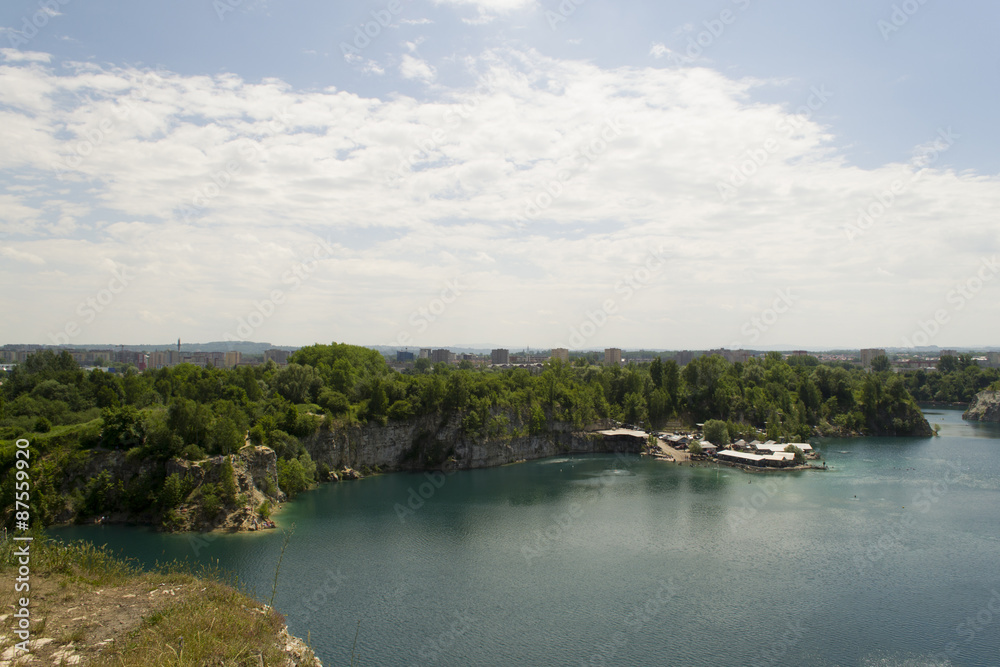 Limestone quarry lake with deep blue water and steep walls