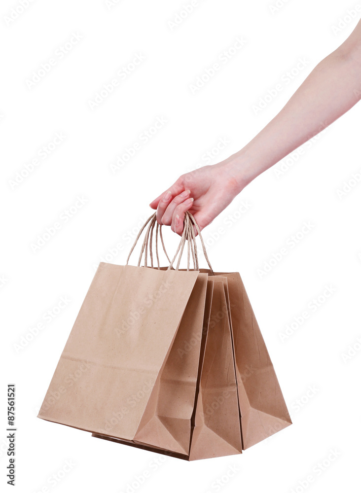 Female hand holding paper shopping bag isolated on white
