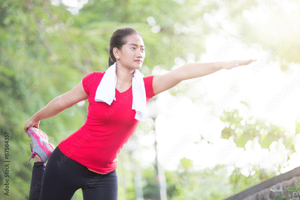 Asian woman doing stretching exercise during outdoor cross train Asian woman doing stretching exercise during outdoor cross train