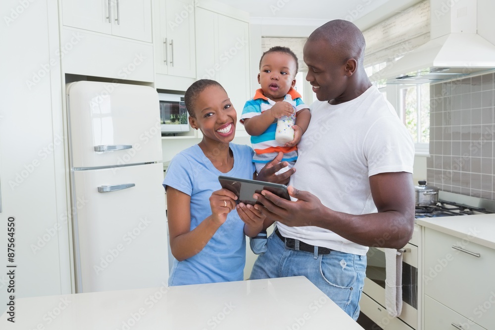 Obraz premium Happy smiling couple with his babyboy using digital tablet 