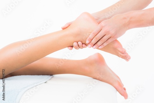 Woman receiving leg massage at spa center