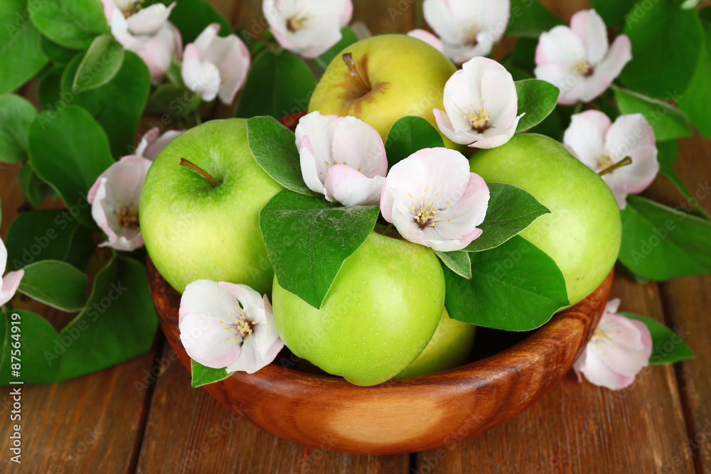 Fresh apples with apple blossom in bowl, on wooden table Fresh apples with apple blossom in bowl, on wooden table