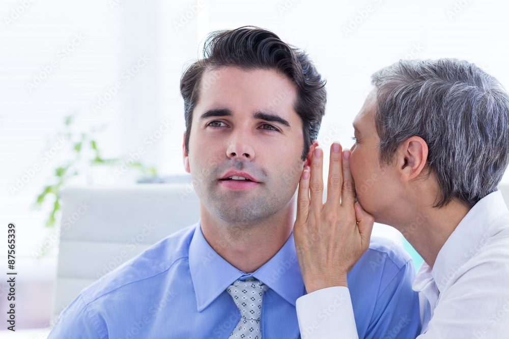 Two business people looking at a paper while working on folder Two business people looking at a paper while working on folder