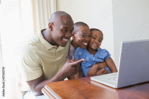 Happy smiling family using laptop