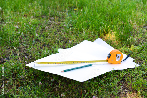 Building roulette and pencil on white sheets of paper, outdoors photo