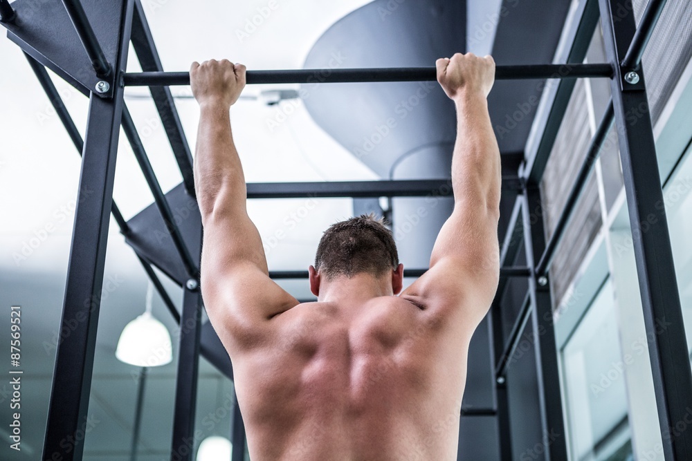 Naklejka premium Back view of muscular man doing pull ups