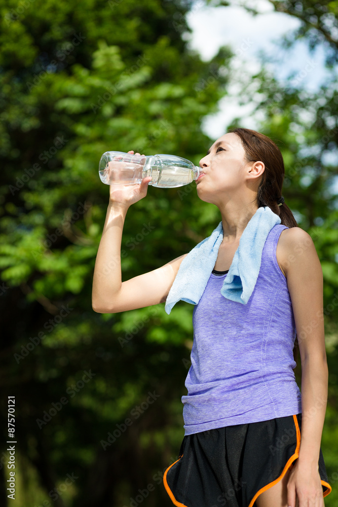 Young female athlete drinking water to refresh Young female athlete drinking water to refresh