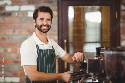 Smiling barista preparing a coffee