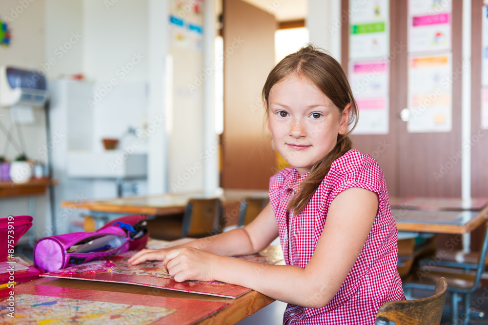 Indoor portrait of a cute little girl in a classroom