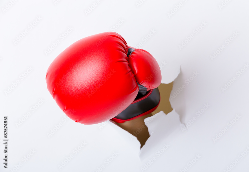Hand break through paper with boxing gloves