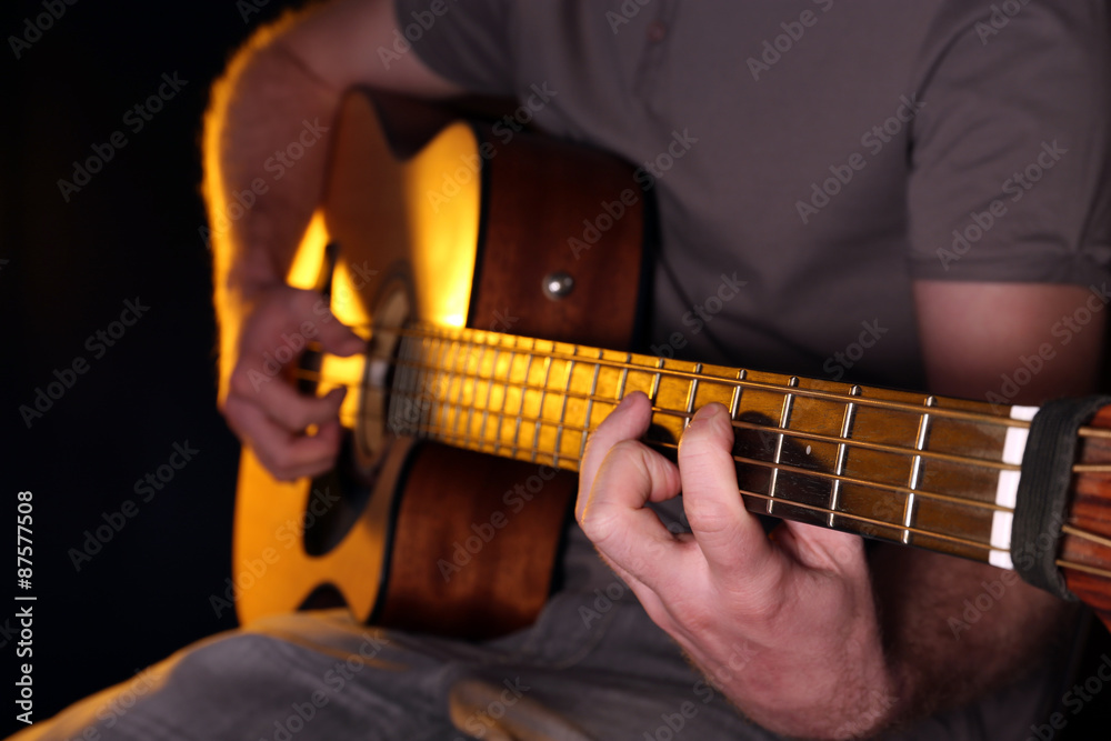 Obraz premium Young man playing on acoustic guitar close up