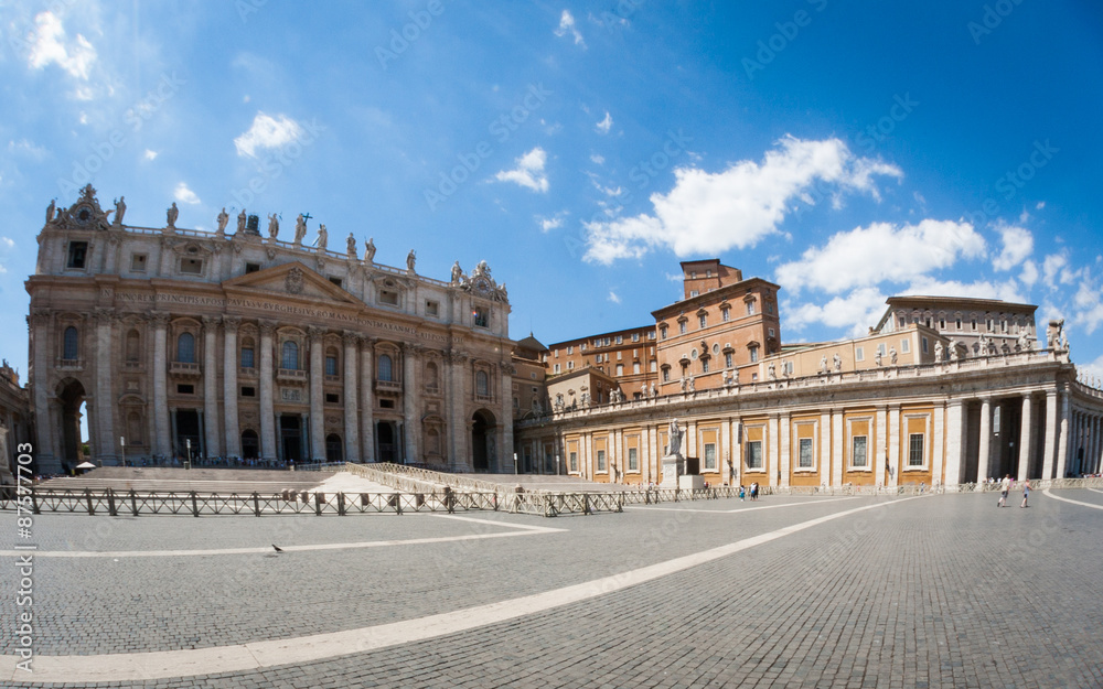 A super-wide fish-eye view of the popular tourist attraction St. Peter's Square in the Vatican City with the Basilica and Popes palace creating a background to the tourists and pilgrims.