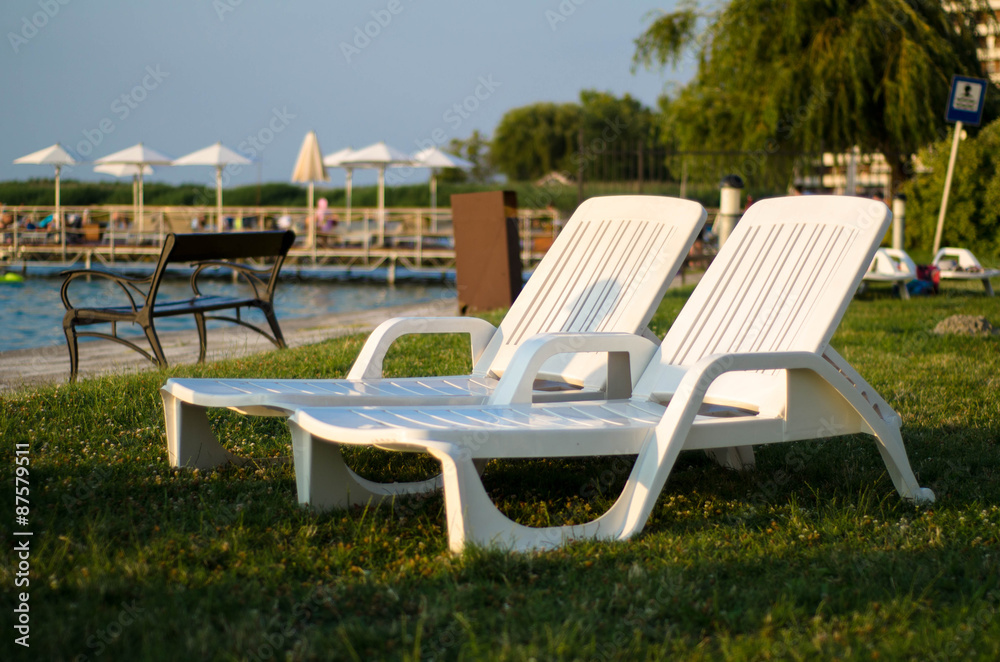 Fototapeta premium Two white chairs at the beach in the summer. Travel concept