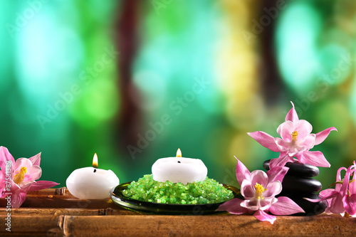 Beautiful spa composition with flowers and candles on bright background