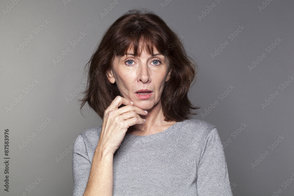 unhappy mature woman with brown hair and grey sweater thinking,looking concerned or questioning unhappy mature woman with brown hair and grey sweater thinking,looking concerned or questioning