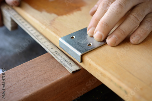 Schreiner oder Handwerker beim Anzeichnen von Holz für Terrasse 