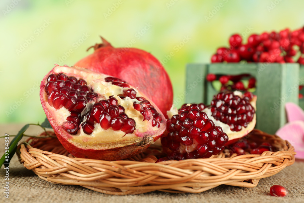 Pomegranate seeds on wicker tray on green blurred background Pomegranate seeds on wicker tray on green blurred background