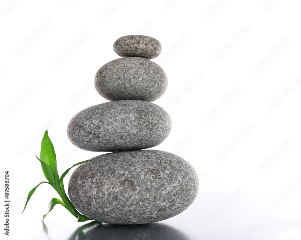 Stack of spa stones with green leaves isolated on white Stack of spa stones with green leaves isolated on white