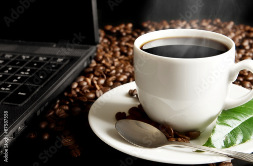 Cup of coffee with mist laptop coffee leaf at breakfast