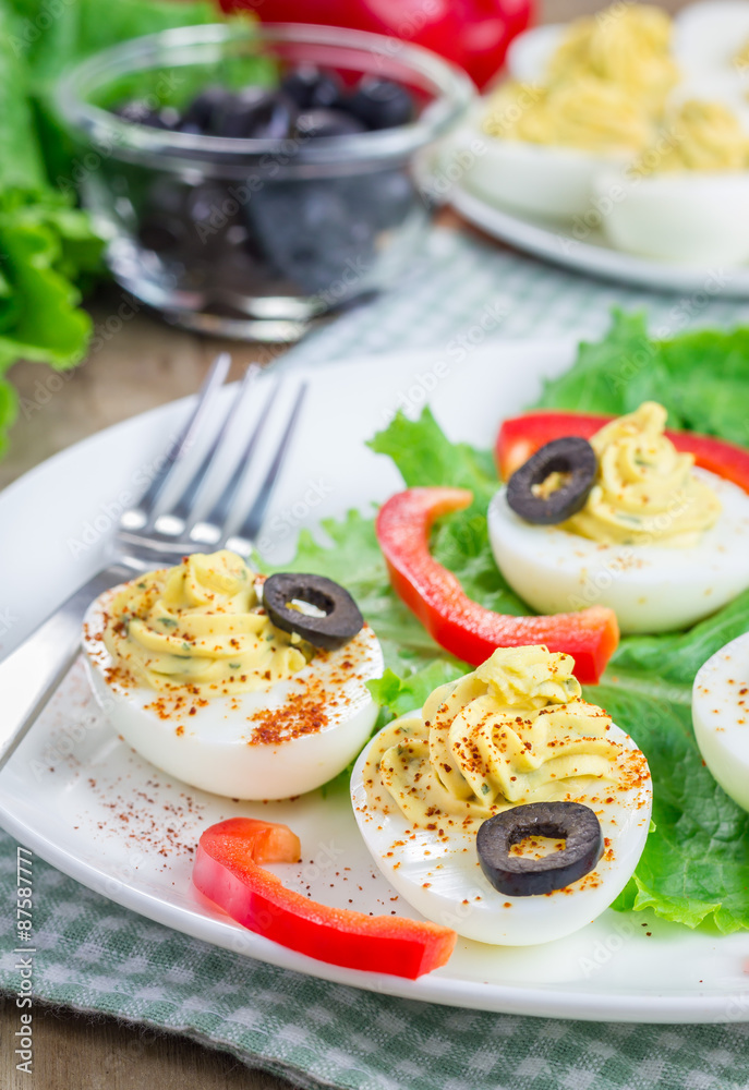 Spicy deviled eggs garnished with olives and paprika Spicy deviled eggs garnished with olives and paprika