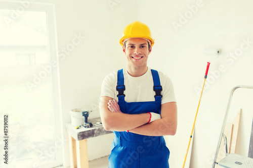 smiling young builder in hardhat indoors
