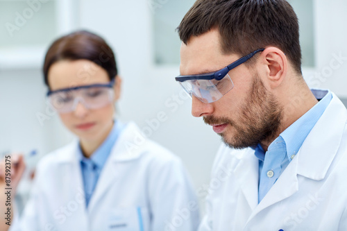 close up of young scientists at laboratory