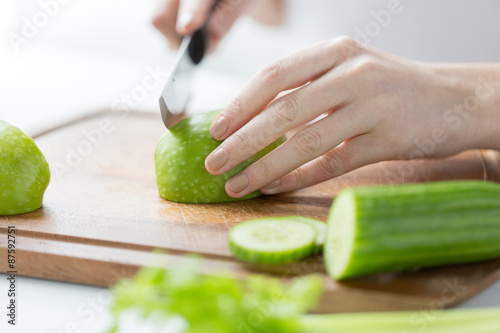 close up of woman hands chopping green vegetables