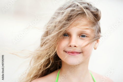 Close-up Portrait of a pretty smiling little girl with waving in