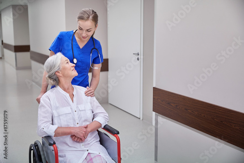 nurse with senior woman in wheelchair at hospital