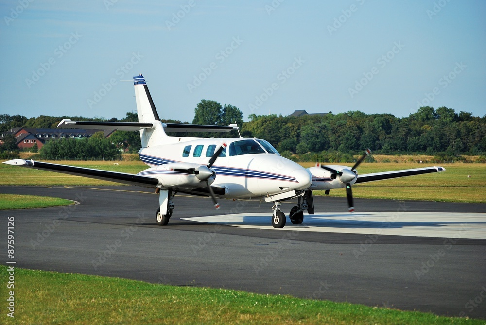 Kleine zweimotorige Propellermaschine ist zum Start bereit, und wartet auf der Startbahn auf das Okay vom Tower