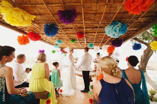 beautiful  gorgeous blonde bride with orchids and stylish groom, hawai colorful ceremony  on cyprus