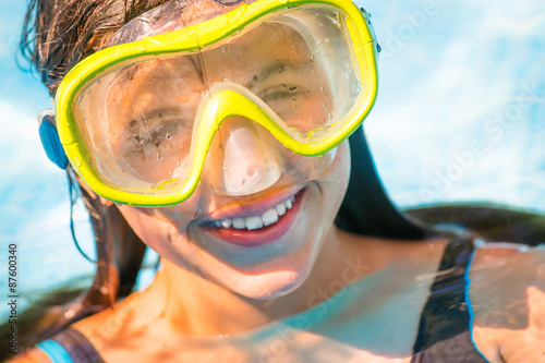 Beautiful portrait of young smiling girl in the water with diving mask on her head