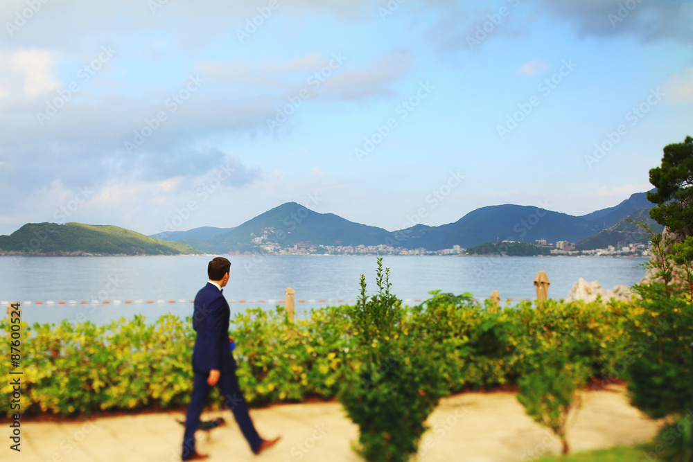 beautiful young rich groom walking on the beach with Yorkshire T