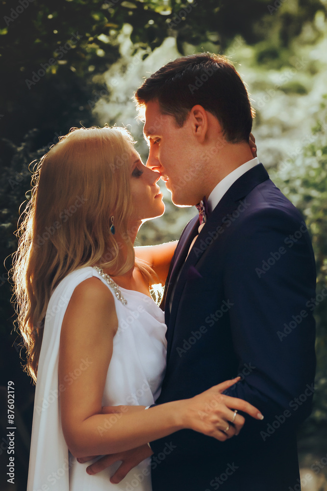 in love cute bride and groom look at each other in the midst of green leaves light falls Montenegro in love cute bride and groom look at each other in the midst of green leaves light falls Montenegro