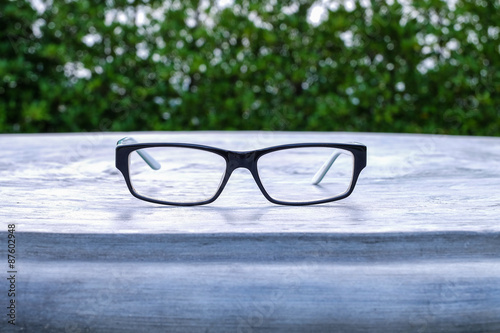 Glasses on table in the park with blurred tree background