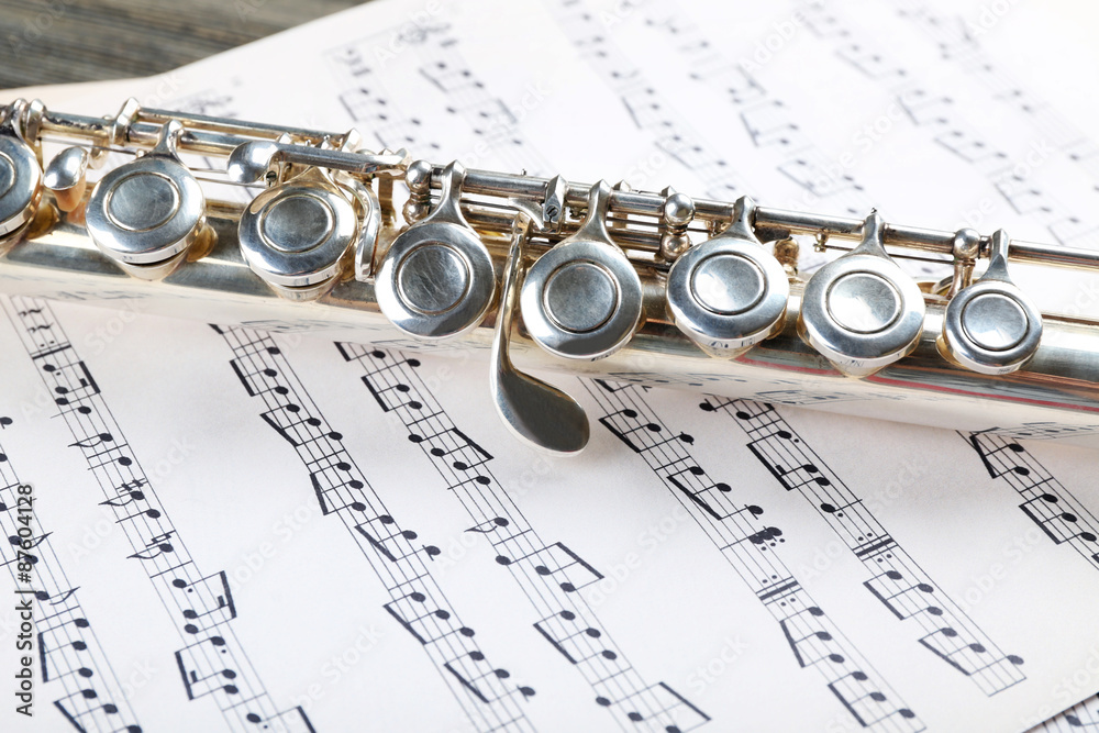 Fototapeta premium Silver flute on music notes background