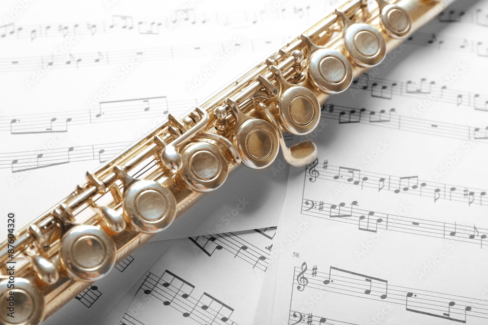 Naklejka premium Silver flute on music notes background