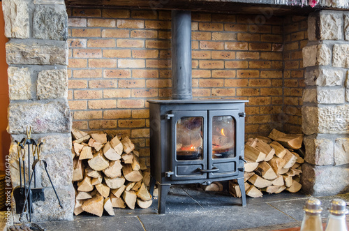 Tableau sur toile Wood Burning Stove in a Brick Fireplace
