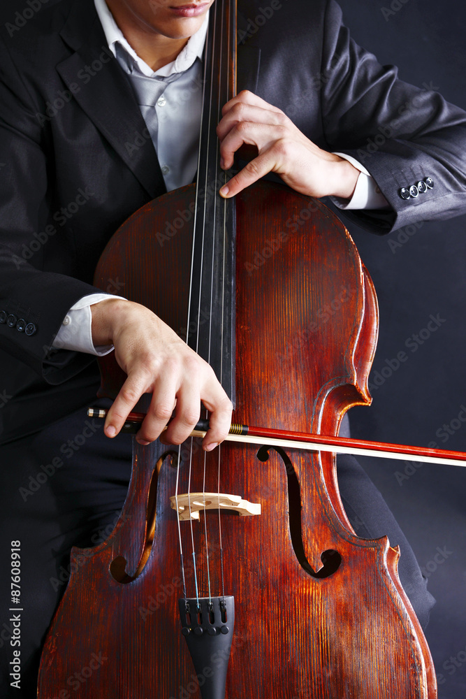 Man playing on cello on dark background Man playing on cello on dark background