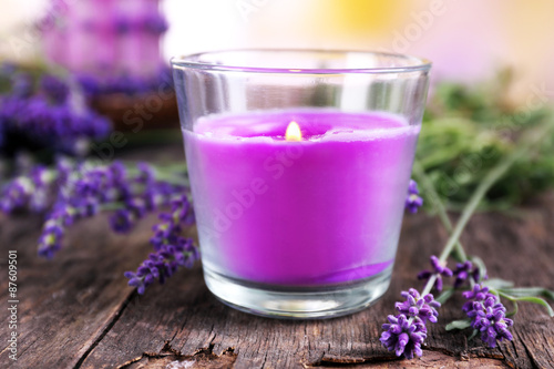 Candles with lavender flowers on table close up